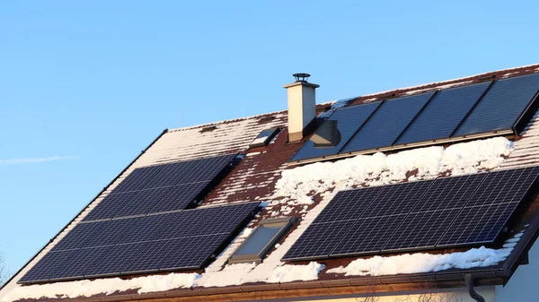 太陽電池パネルと熱太陽電池パネル 家の屋根の上のエネルギー生産 冬の太陽系のセルフクリーニング効果 — ストック写真