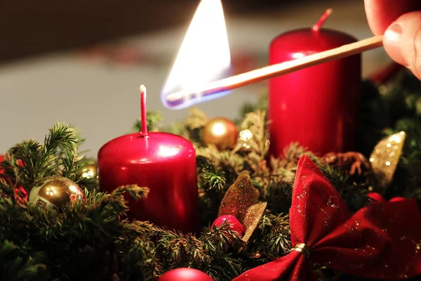 Noel mumları yakıyorum. Dekoratif şamdan. El bir mum yakar.