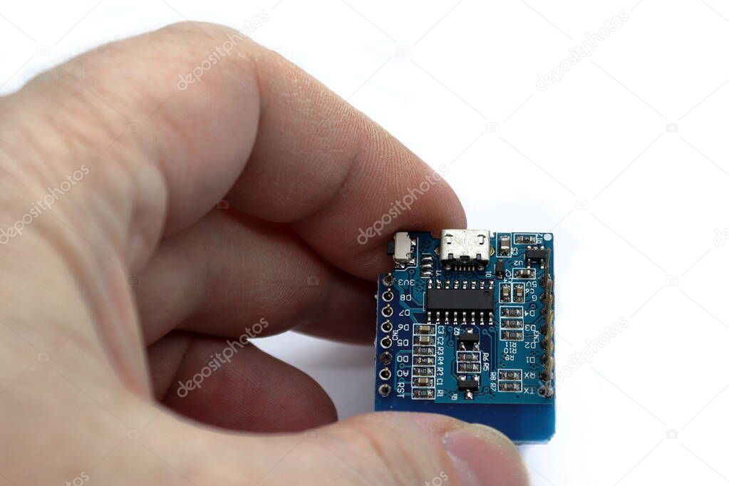 Hand holding a circuit board with a microchip. Detail of microchips on an electronic circuit board. Standard marking of electronic components. Electronic chips and electronic components.