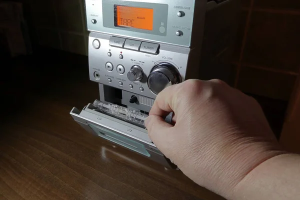El, kaseti bir ses kaydedicinin içine koyuyor. Retro müzik kaydı ve çalma. 90 'lar.