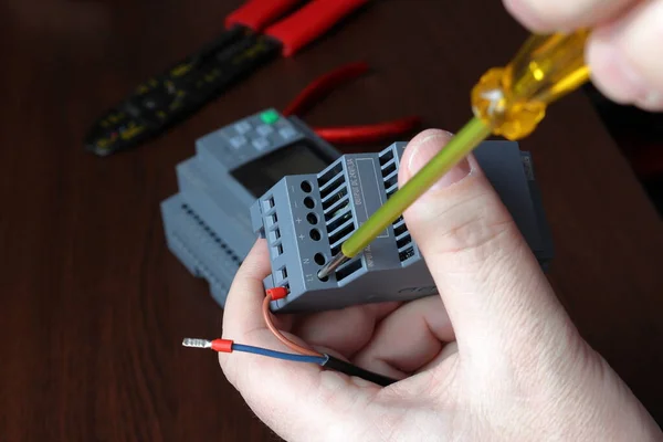 Elektrik mühendisi güç kablosunu güç kaynağına bağlıyor. Kablo bağlantısı ayrıntısı.