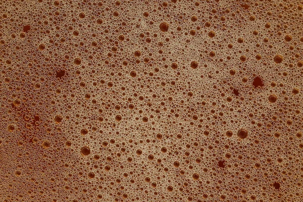 Saw-gold köpüğü. Işıkla aydınlatılan baloncukların ayrıntıları. Bira köpüğü dokusu. Pürüzlü yüzey.