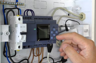 PLC 'yi kuran eli kapat. Endüstriyel kontrol sisteminin test ve programlanması.