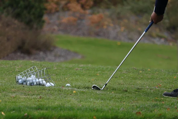 ゴルファーは長いショットを練習する バスケットにはゴルフボールがいっぱい 緑の草 — ストック写真
