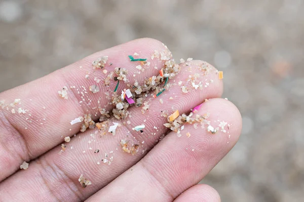 Close-up of microplastics on hand From the natural environment, the concept of water pollution and global warming. on natural climate change