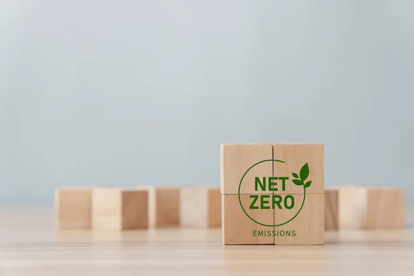 Net Zero and Carbon Neutral concept, green icon on a wooden block. Zero net greenhouse gas emissions target A climate-neutral long-term strategy