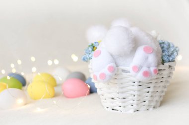 Sepette tavşan, Paskalya yumurtası, arka planda çelenk ve bokeh, Paskalya fotoğrafı.