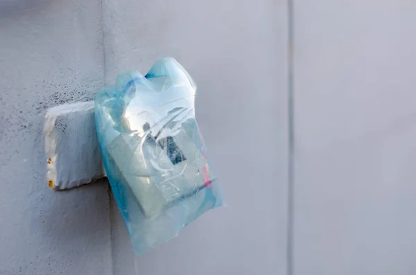Gri ve mavi renkli kesilmiş plastik şişeden yapılmış asma kilit için kötü hava koşullarından korunma.
