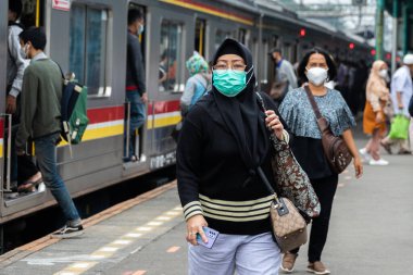 İnsanlar Jakarta, Endonezya 'daki banliyö istasyonunda hala maske kullanıyordu. Endonezya 'daki korona virüsü vakaları düşmeye devam ediyor. 6 Kasım 2021 'de bile, Endonezya' da olumlu vakaların eklenmesi Ocak 2021 'den bu yana görülen en düşük rakamdı..