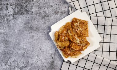 Geleneksel Rus maya ince krepleri (krepler) beyaz kare bir tabakta koyu arkaplanda. Üst manzara, düz uzanma