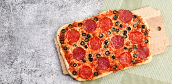 Prostokątna Pizza Pepperoni Serem Oliwkami Prostokątnej Desce Krojenia Ciemnoszarym Tle — Zdjęcie stockowe