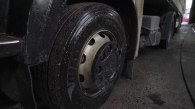 Kamyon tekerleği ince bir su akıntısı ya da özel bir çözeltiyle sulanıyor.
