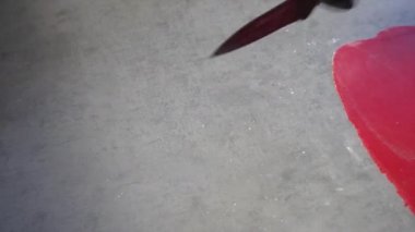 Bıçakla kırmızı bir mastiğin çizgilerini kesiyorlar.