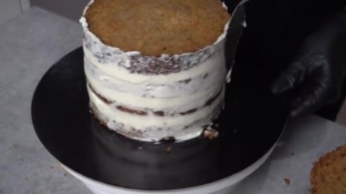 Yüksek pastanın kenarları bir daire şeklinde kremayla kaplıdır. Yukarıdan görünüşü