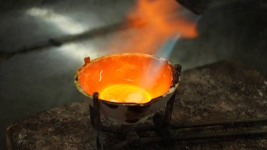 Değerli metal bir gaz ocağıyla ısıtılarak eritilir. Yakın plan..    