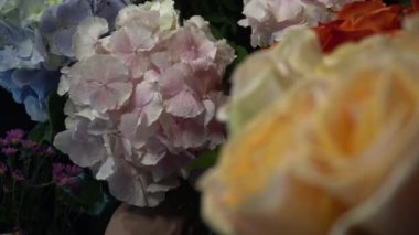 Pembe ve mavi ortanca çiçekleri vazodan buket yapmak için çıkarılır.