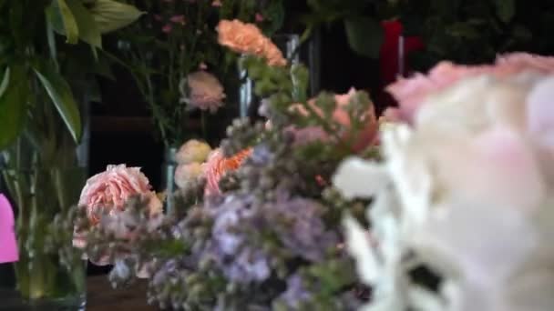 Kwiaciarnia Trzyma Bukiet Róż Dodaje Niego Róże Zbliżenie — Wideo stockowe