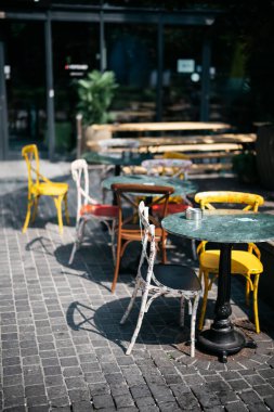 Güneşli bir günde açık hava restoranında masa ve sandalyeler.