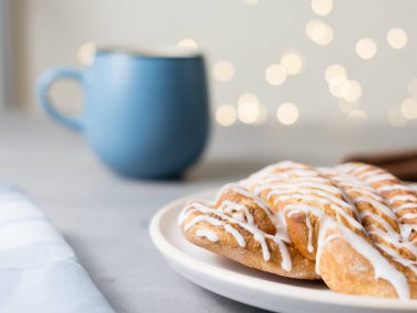 Tarçınlı çörek ya da tarçınlı çörek tabakta mavi fincan kahve. Klasik Amerikan ya da Fransız fırınları. Bokeh