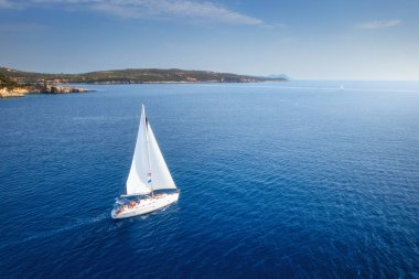 Güzel bir yatın havadan görünüşü. Yazın gün batımında denizde tekne gezisi. Lefkada Adası, Yunanistan. Lüks yatlar, yelkenliler, temiz mavi sular, gökyüzü, dağ manzarası. Seyahat et. Seyahat tatili. Yat.