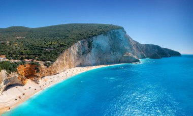 Mavi deniz manzarası, dağlar, yazın güneşli bir günde beyaz kumlu plaj. Panorama. Porto Katsiki, Lefkada Adası, Yunanistan. Deniz kıyıları, kayalar, gök mavisi su ve gökyüzü olan güzel bir manzara. Üst görünüm