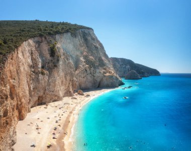 Yazın güneşli bir günde mavi deniz, kaya ve kumsal manzarası. Ünlü Porto Katsiki, Lefkada Adası, Yunanistan. Deniz kıyısının güzel manzarası, yüzen insanlar, gök mavisi su. Üst Manzara. Seyahat