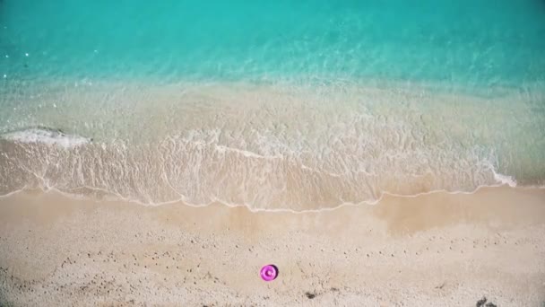 Aerial view of the pink swim ring on the sandy beach near sea — Stockvideo