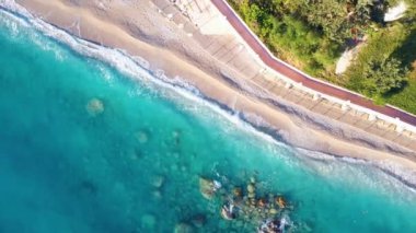 Mavi denizin havadan görünüşü, berrak sulardaki kayalar, beyaz kumlu plaj.