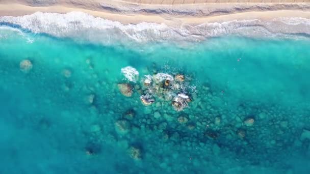 Вид с воздуха на голубое море, скалы в чистой воде, белый песчаный пляж — стоковое видео