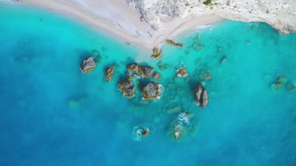 Aerial view of blue sea, rocks in clear water, white sandy beach — ストック動画