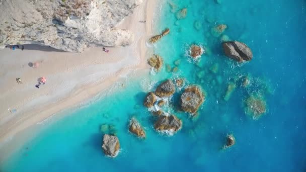 Aerial view of blue sea, rocks in clear water, white sandy beach — Wideo stockowe