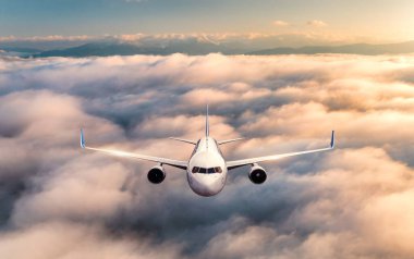 Uçak yazın gündoğumunda bulutların üzerinde uçuyor.