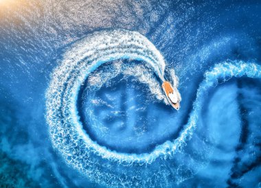 Yazın günbatımında şeffaf mavi suda sürat teknesinin hava görüntüsü. Akdeniz 'de yüzen yatın insansız hava aracı görüntüsü. Motorlu, tropik renkli bir arazi. Aşırılık