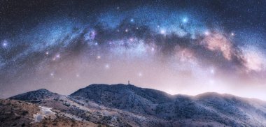 Yıldızlı gecede Samanyolu dağ tepelerinin üzerinde kemer. Yunanistan 'ın Lefkada kentinde parlak yıldızlı ve kavisli bir gökyüzü. Doğa. Güzel dağ manzarası. Uzay arkaplanı. Galaksi