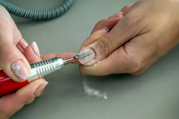 Jel ojesini bir kesici ve değirmenciyle çıkarma işlemi. Kadınların tırnaklarındaki cilayı sökmek. ev makinesi manikürü