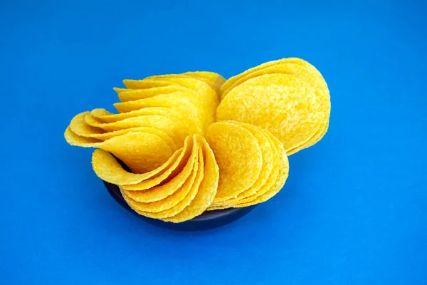 Ronde Chips Liggen Een Kleine Zwarte Plaat Blauwe Achtergrond Bron — Stockfoto