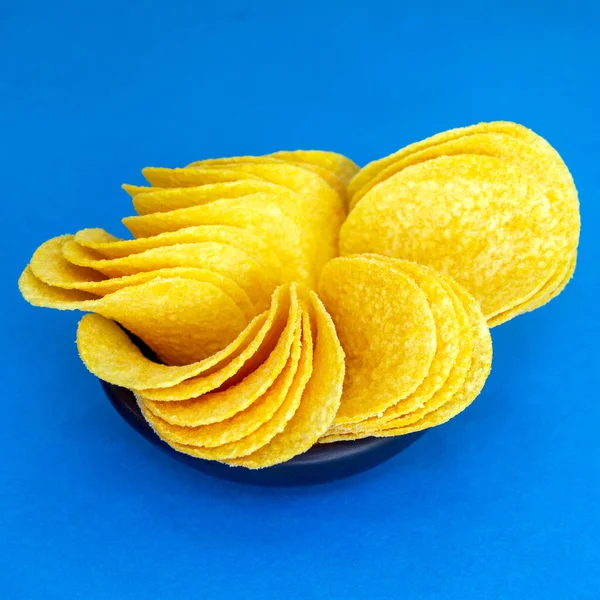 Ronde Chips Liggen Een Kleine Zwarte Plaat Blauwe Achtergrond Bron — Stockfoto