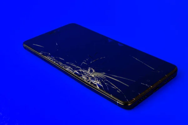 Mobiltelefon Törött Képernyőn Fekszik Kék Háttér Elromlott Okostelefon Elektronikus Kütyü — Stock Fotó