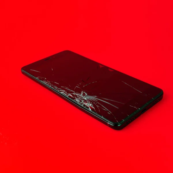 Мобильный Телефон Сломанным Экраном Лежит Красном Фоне Сломанный Смартфон Электронный — стоковое фото