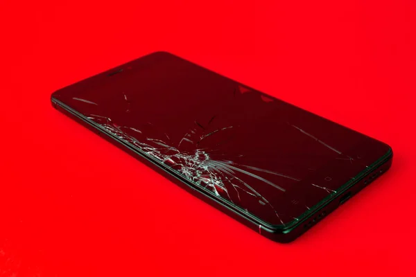 Egy Törött Képernyős Mobiltelefon Fekszik Piros Háttérben Egy Elromlott Okostelefon — Stock Fotó