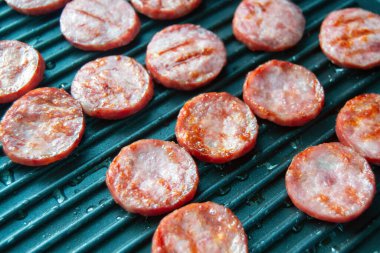 Izgara sosis dilimleri. Izgara tavasında sosisler. Piknik. Yağlı et. Yarı bitmiş ürünlerin hazırlanması