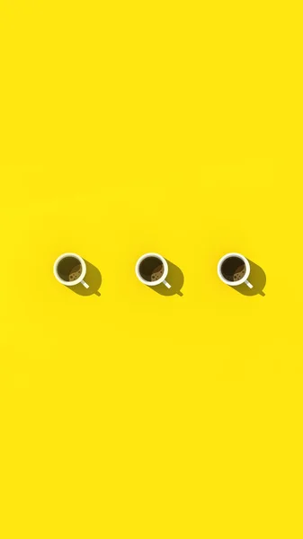 Három Csésze Fehér Kávé Sárga Háttérrel Felülnézetből Függőleges Kép Kép — Stock Fotó