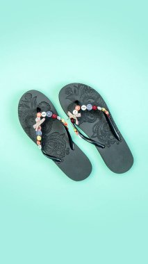 Mavi arka planda parmak arası terlikler. Plaj terlikleri yakın plan. Yaklaşan tatil. Dikey resim