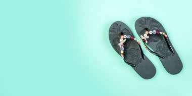 Mavi arka planda parmak arası terlikler. Plaj terlikleri yakın plan. Yaklaşan tatil. Bölgeye yerleştirme pankartı. Metin koşu alanı için yer. Yatay resim