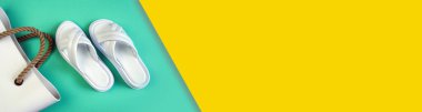 Beyaz kadın terlikleri ve mavi sarı arka planda kahverengi saplı beyaz kauçuk bir çanta. Terlikler. Bölgeye yerleştirme pankartı. Metin koşu alanı için yer. Yatay resim