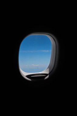 Gökyüzü ve tarlaları çerçeveleyen bir uçağın penceresi.