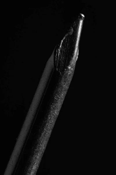 Details of the tip of a nail on a black background