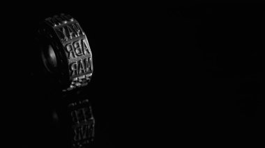 Nisan ayına sahip metal tekerlek siyah beyaz yansıyor.