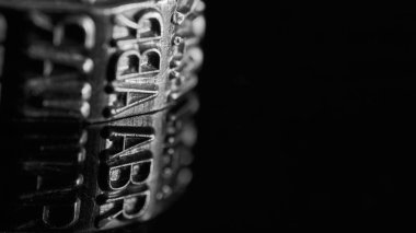 Nisan ayına sahip metal tekerlek siyah beyaz yansıyor.