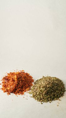 Details of a mountain of oregano and ground chili on a white background